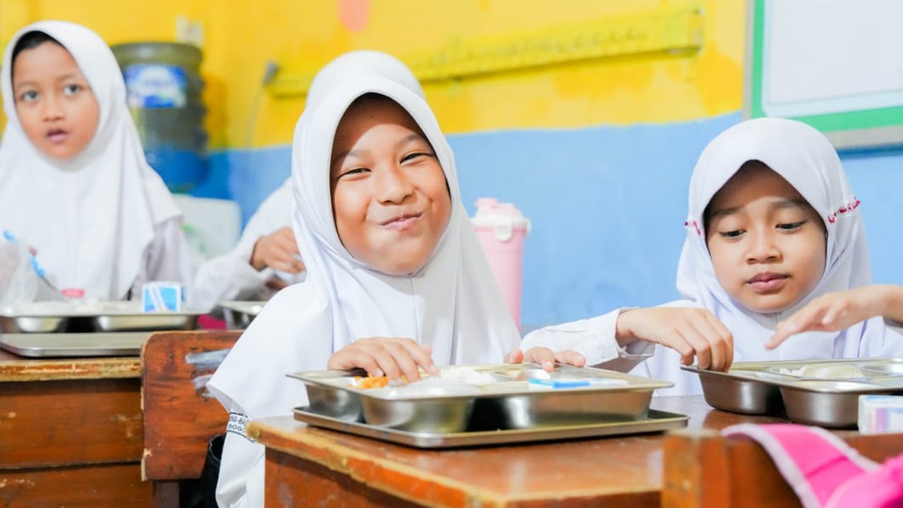 Siswa SDN Kedung Badak 1 tampak bahagia menikmati Program Makan Bergizi Gratis.