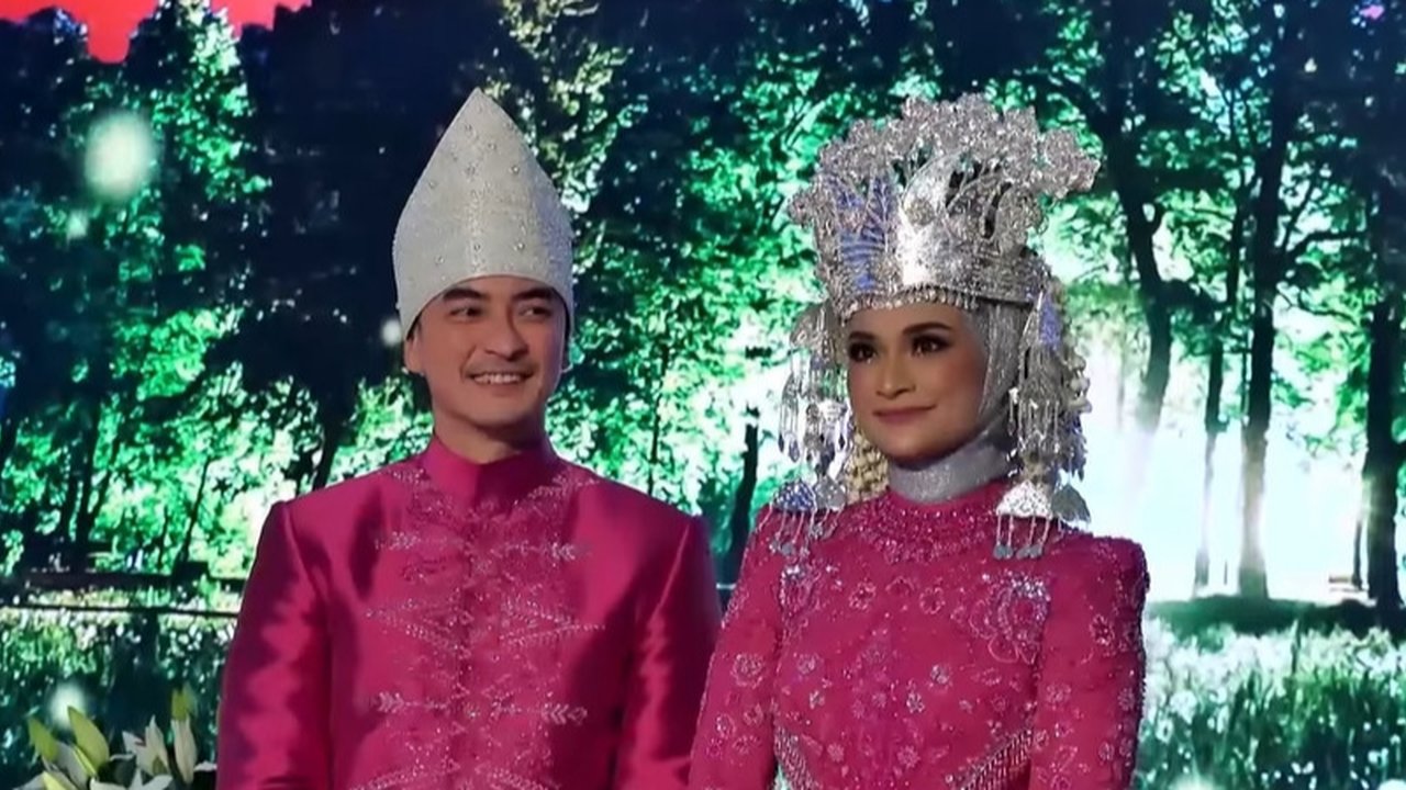 Untuk acara resepsinya, Putri dan Zumi memilih warna pink fuschia. Kebaya modern ini dipadukan dengan mahkota adat Jambi, daerah asal Zumi Zola.