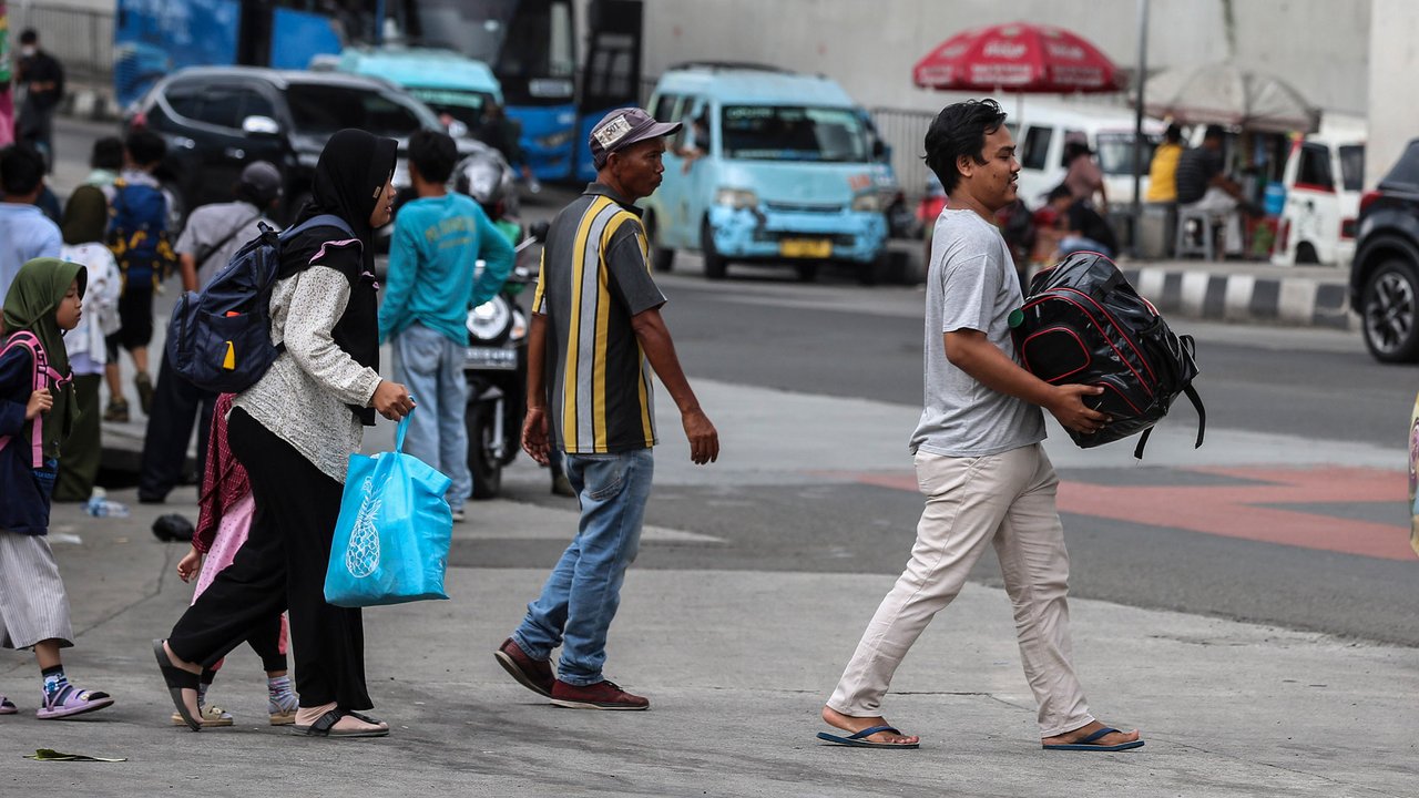 Pemudik arus balik Lebaran Idul Fitri 2023 berjalan saat tiba di Terminal Lebak Bulus, Jakarta, Rabu (26/4/2023). (Liputan6.com/Johan Tallo)
