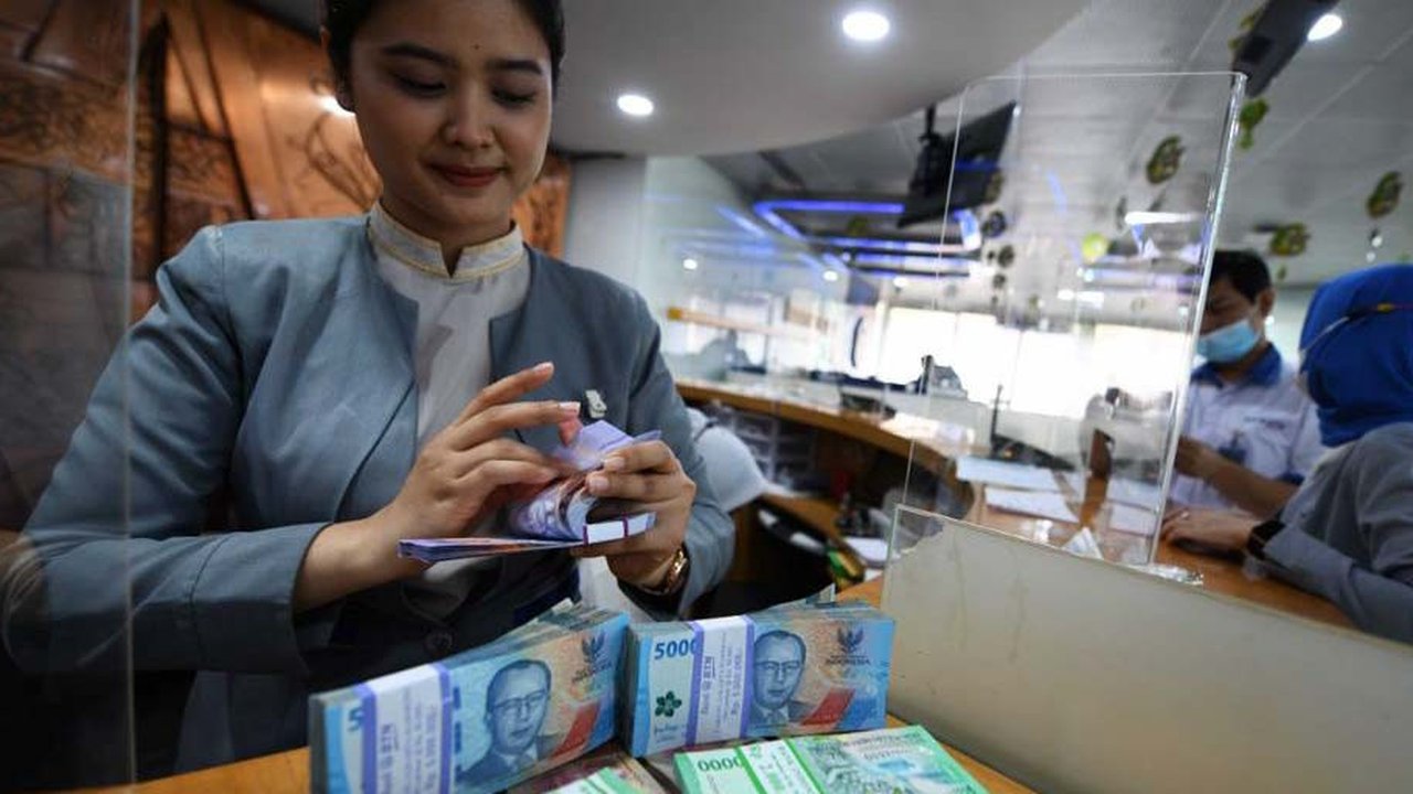 Teller Bank BTN menghitung uang pecahan baru untuk melayani kebutuhan nasabah di Kantor Cabang Bank BTN Harmoni, Jakarta (26/4/2023). (Liputan6.com)