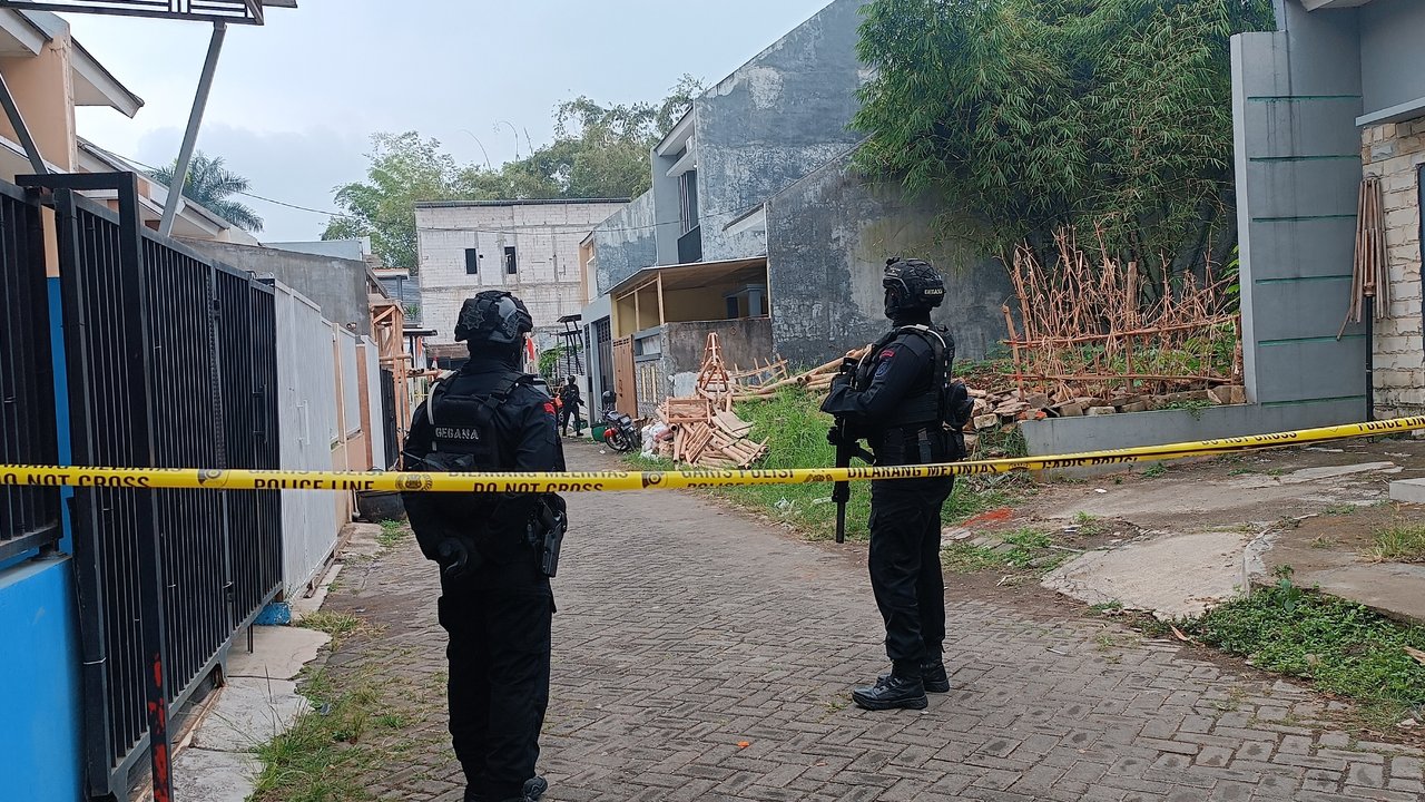Tim Densus 88 Antiteror berjaga ketat di sebuah rumah yang dihuni seorang terduga terorisme di Kota Batu pada Kamis, 1 Agustus 2024 (Liputan6.com/Zainul Arifin)