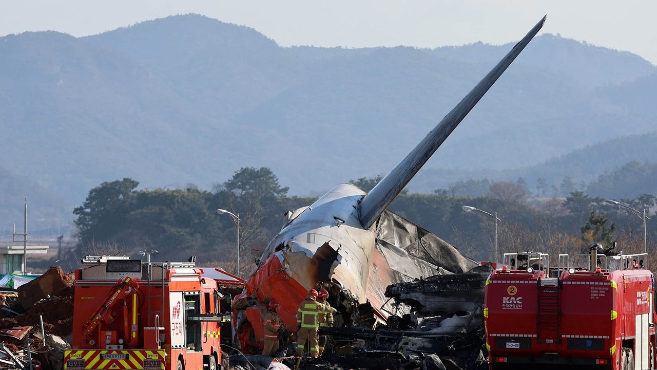 Asap mengepul hitam dari  bagian ekor pesawat Boeing 737-800 seri Jeju Air setelah pesawat jatuh dan terbakar di Bandara Internasional Muan di Provinsi Jeolla Selatan, Koorea Selatan, Minggu (29 /12/2024). Pesawat  Jeju Air yang membawa  175 penumpang dan enam awak dengan rute penerbangan  dari Bangkok ke Korea Selatan jatuh menyebabkan  29 penumpang tewas dan penumpang lainnya luka-luka
Foto: AFP/ YONHAP