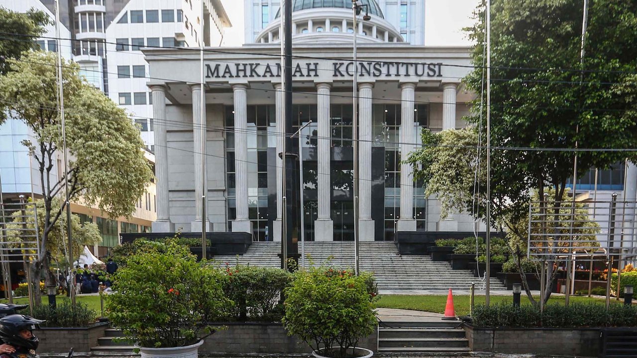 Petugas memasang beton pembatas dengan kawat berduri di halaman depan Gedung Mahkamah Konstitusi (MK) di Jakarta, Senin (25/3/2024). (Liputan6.com/Angga Yuniar)