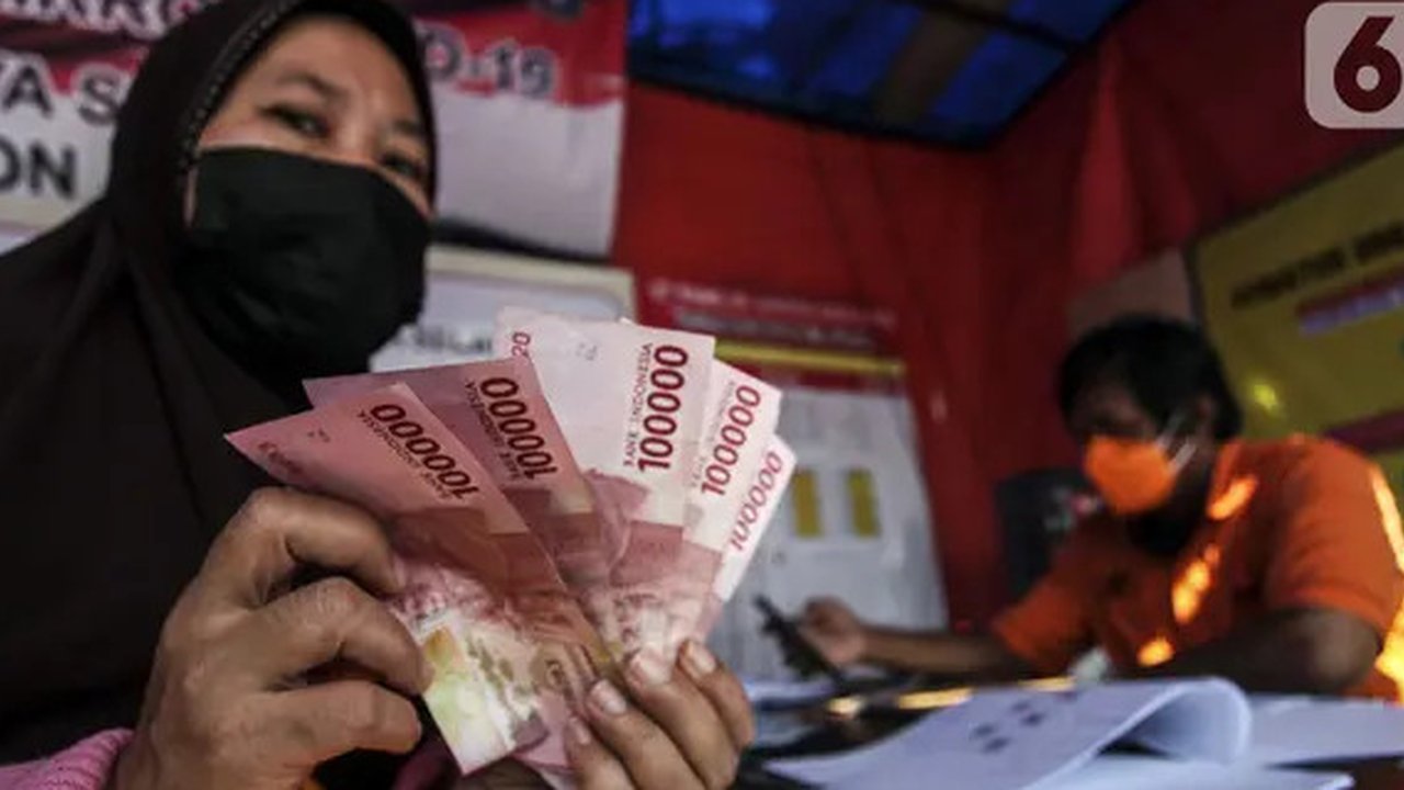 Warga menunjukkan uang bantuan sosial (bansos) di kawasan Kedoya Selatan, Jakarta Barat, Rabu (28/7/2021). Bansos berupa uang tunai sebesar Rp 600 ribu tersebut disalurkan oleh PT. Pos Indone