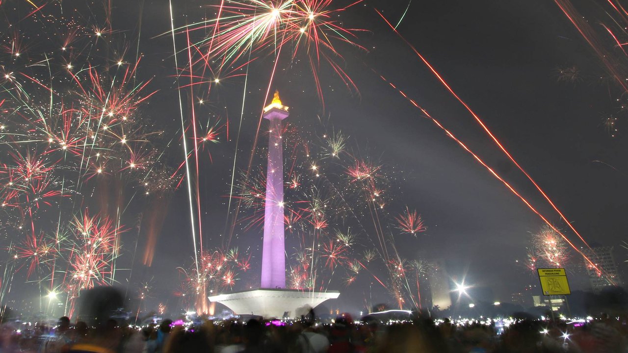 Kembang api menghiasi langit di kawasan Monas, Jakarta, Jumat (1/1). Antusiasme warga yang memadati Monas saat malam pergantian tahun membuat langit di kawasan tersebut dimeriahkan dengan pesta kembang api. (Liputan6.com/Immanuel Antonius)