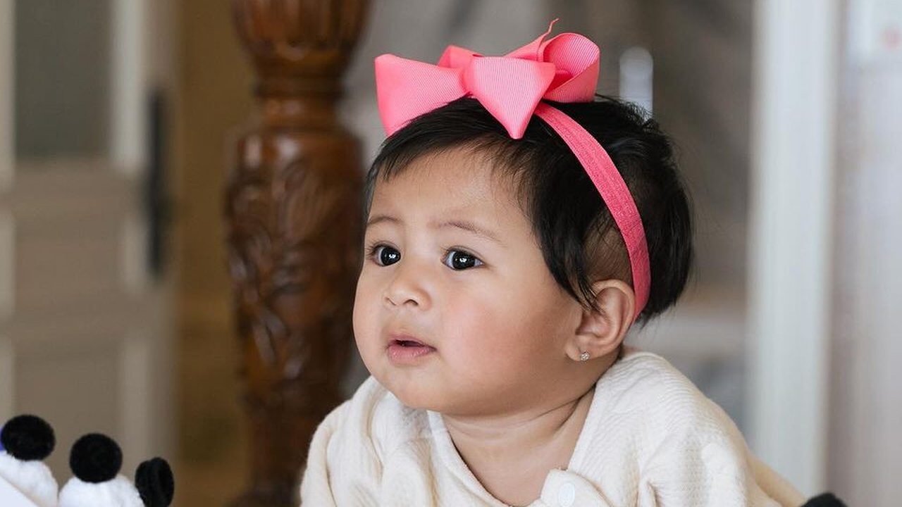 Potret Lily dengan Pita Pink di Kepala, Super Gemas Pose di Atas Kasur
