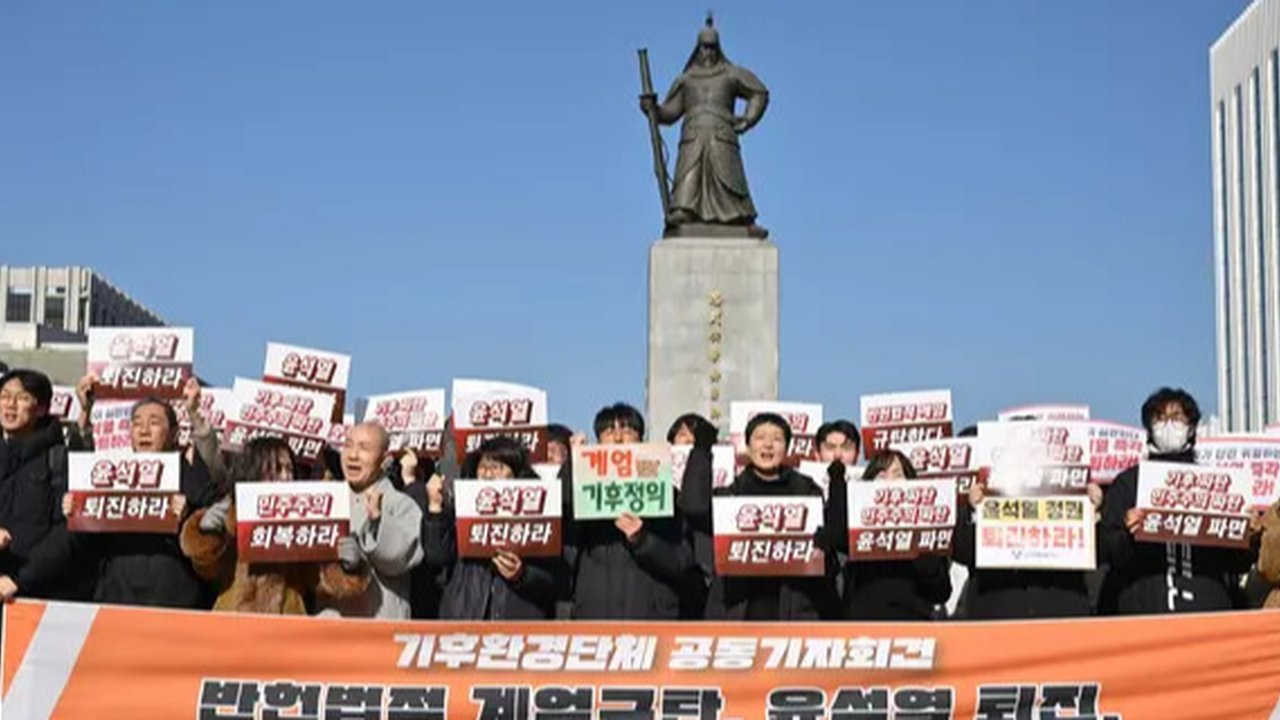 Para pengunjuk rasa memegang plakat dalam unjuk rasa yang menyerukan pengunduran diri Presiden Korea Selatan Yoon Suk Yeol di Lapangan Gwanghwamun di Seoul pada 4 Desember 2024. (ANTHONY WALLACE/AFP)
