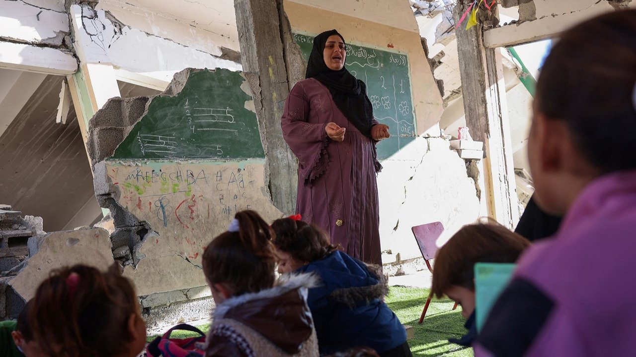 Doha al-Attar mengajar anak-anak di sebuah kelas di antara reruntuhan di Khan Younis, Jalur Gaza, Palestina.
