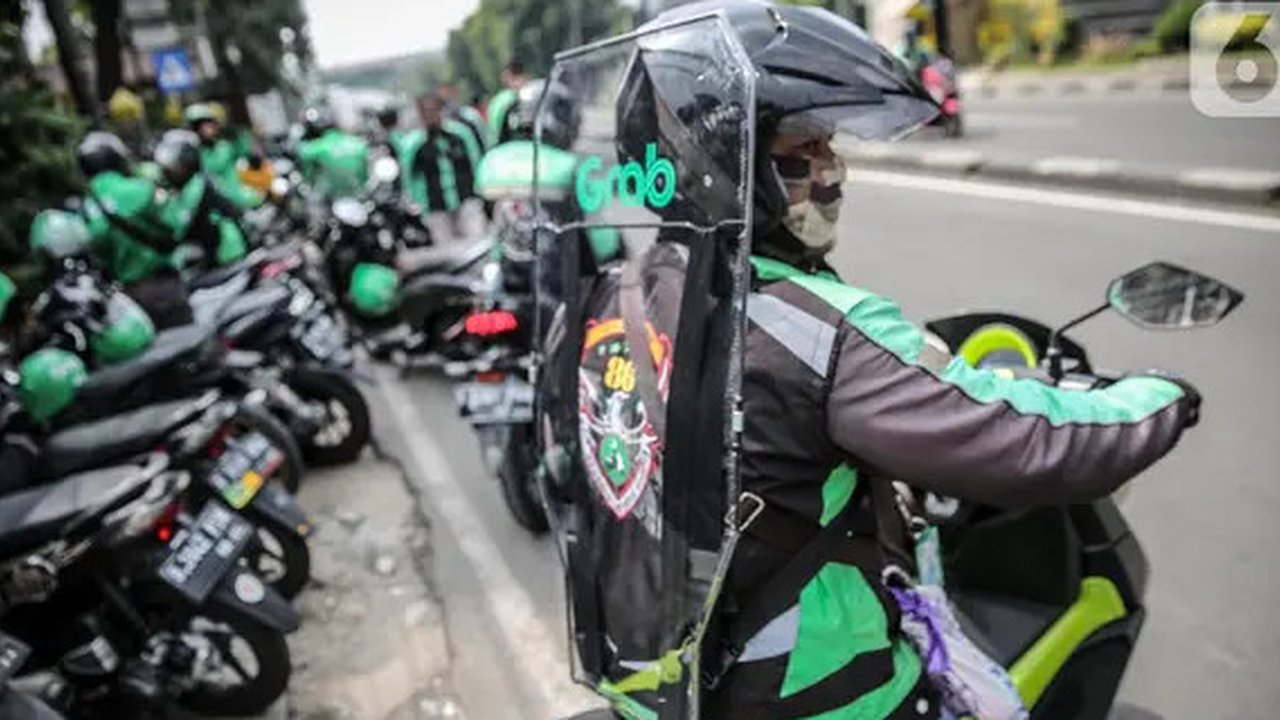 Driver Grab Bike mengenakan Grab Protect pelindung yang membatasi antara pengemudi dan penumpang saat diluncurkan di Jakarta, Selasa (9/6/2020). Penumpang ojek online (ojol) kini tak perlu kh
