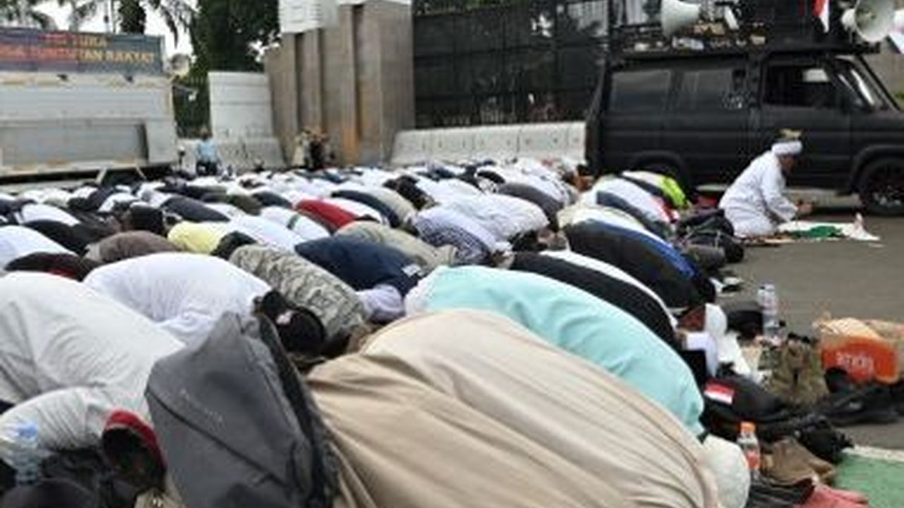FOTO: Momen Pengunjuk Rasa Tuntut Hak Angket Gelar Jumatan di Depan Gedung DPR