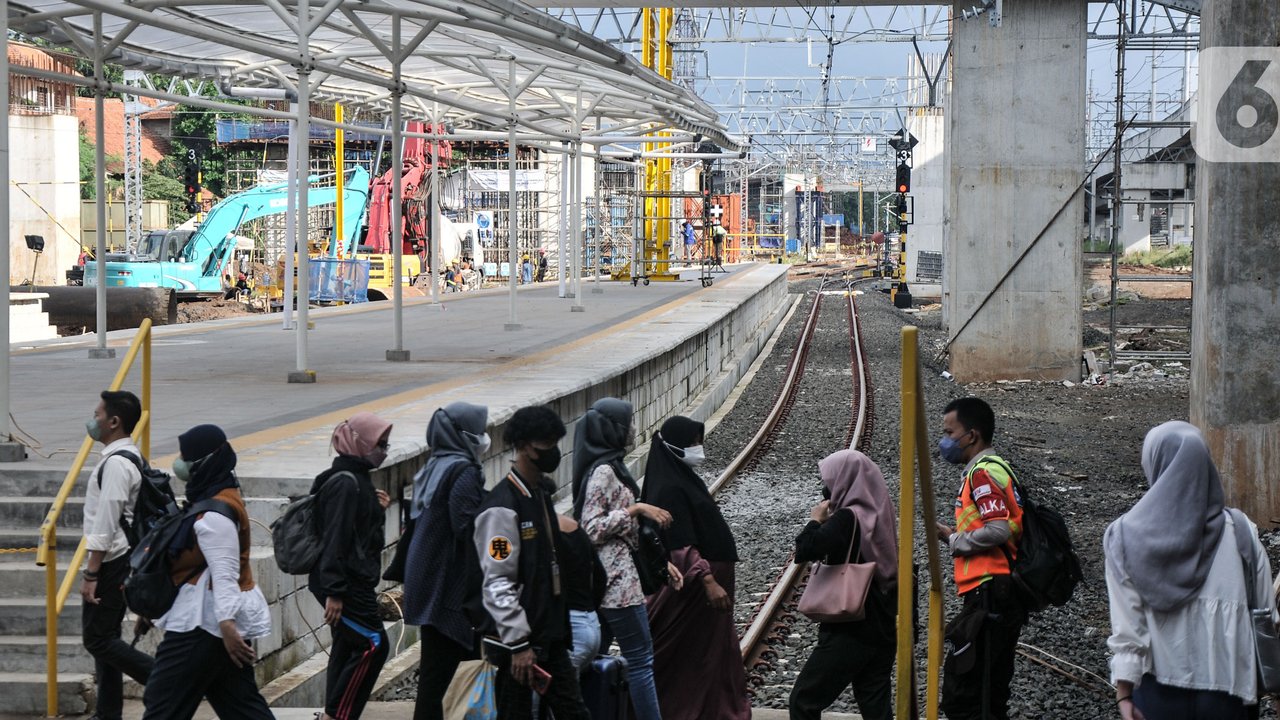 Calon penumpang kereta listrik Commuterline (KRL) saat melintas di dekat proyek pembangunan Stasiun Manggarai, Jakarta, Rabu (22/2/2023). Kepala Balai Teknik Perkeretaapian Wilayah Jakarta-Banten Rode Paulus mengungkapkan, pembangunan Stasiun Manggarai sisi timur tahap II ditargetkan akan selesai 2023. (merdeka.com/Iqbal S Nugroho)