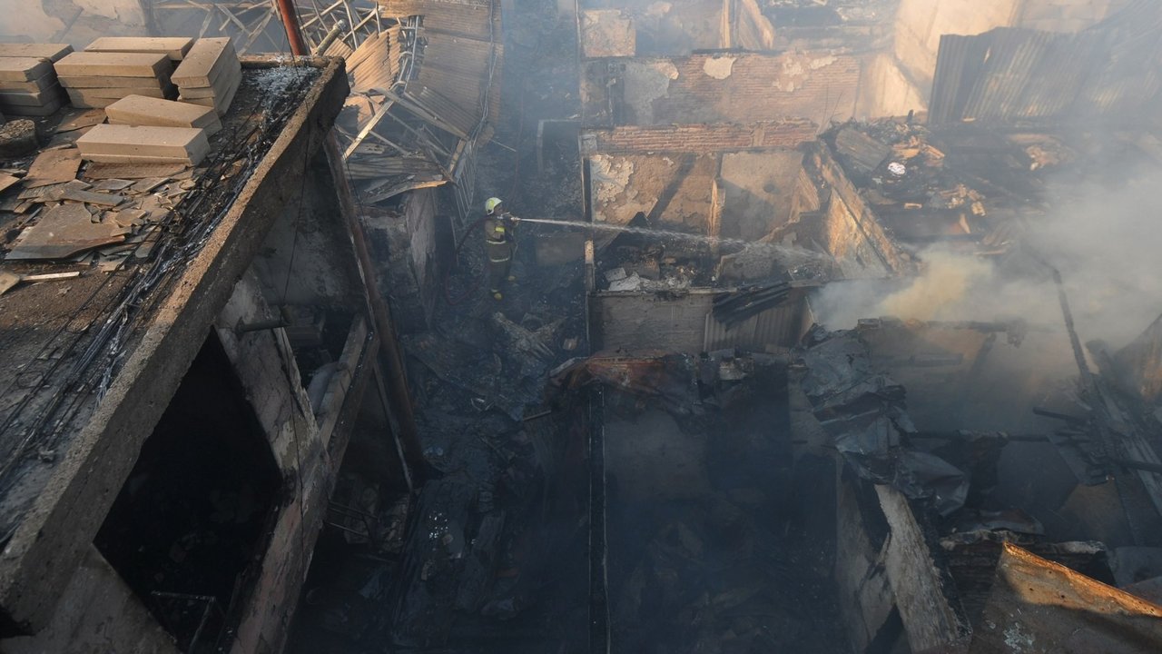 Petugas pemadam kebakaran melakukan pendinginan area pemukiman penduduk yang terbakar di Kawasan Manggarai, Jakarta, Selasa (13/8/2024).