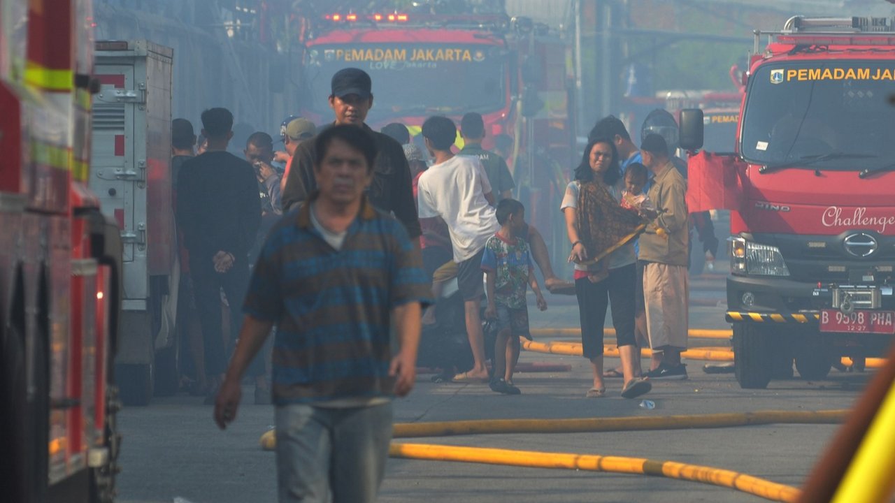 Petugas pemadam kebakaran melakukan pendinginan area pemukiman penduduk yang terbakar di Kawasan Manggarai, Jakarta, Selasa (13/8/2024).