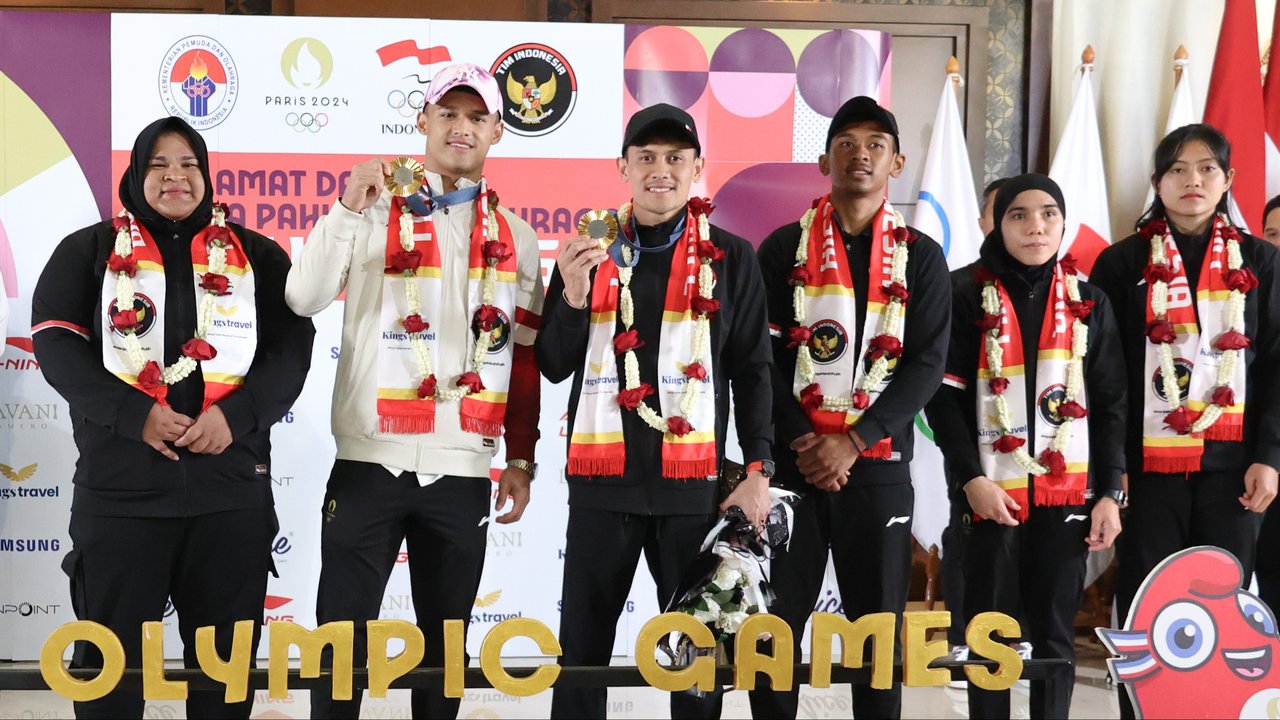 Peraih medali emas Olimpiade Paris 2024 cabang angkat besi nomor 73kg Rizki Juniansyah diangkat oleh teman-temannya sesama lifter usai tiba di Bandara Internasional Soekarno-Hatta, Tangerang, Selasa (13/8/2024). (Abdul Aziz/Bola.com).