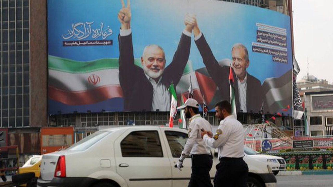 Baliho Presiden Iran, Masoud Pezeshkian dan pemimpin Hamas, Ismail Haniyeh dipajang di Jalan Veliasr, Teheran.