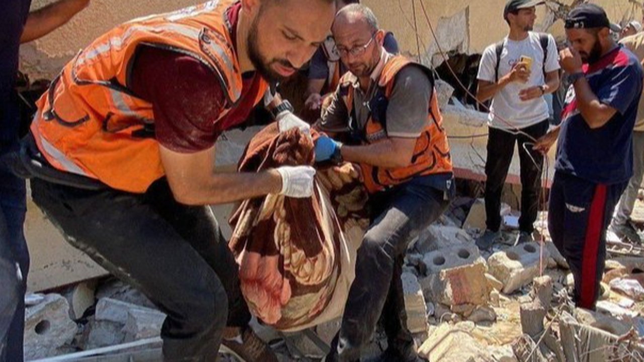 Anggota Pertahanan Sipil Gaza mengevakuasi korban serangan Israel.