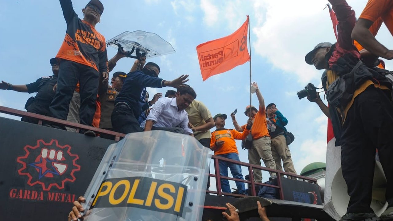 Anggota DPR dari Fraksi Gerindra Habiburokhman dilempar air kemasan saat mencoba beropasi di depan Gedung DPR/MPR, Jakarta, Kamis (23/8/2024).