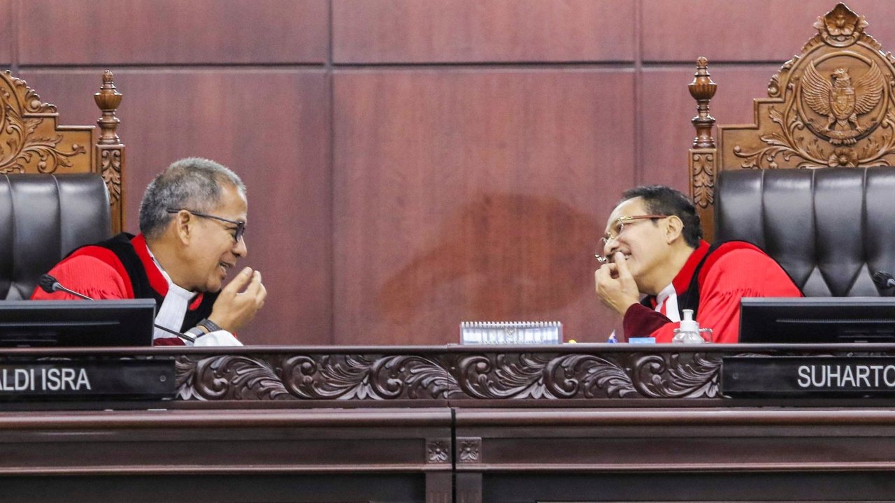 Ketua Mahkamah Konstitusi (MK) Suhartoyo (kanan) berbicara dengan Hakim Konstitusi Saldi Isra (kiri) di sela sidang perkara Nomor 145/PUU-XXI/2023 mengenai uji formil batas usia calon presiden dan calon wakil presiden (capres-cawapres) di Gedung MK, Jakarta, Selasa (16/1/2024). Majelis hakim MK menolak permohonan uji formil batas usia capres dan cawapres yang diajukan pakar hukum tata negara Denny Indrayana dan pengajar UGM Zainal Arifin Mochtar. Liputan6.com/Angga Yuniar