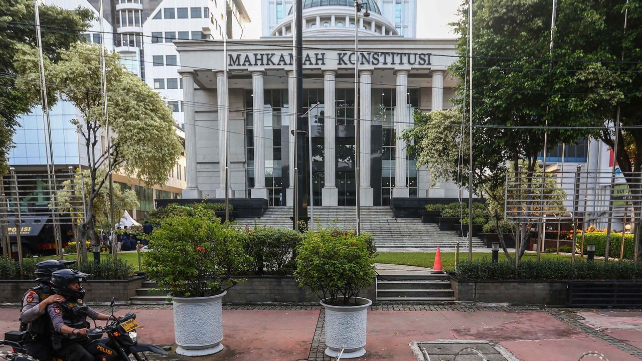 Petugas memasang beton pembatas dengan kawat berduri di halaman depan Gedung Mahkamah Konstitusi (MK) di Jakarta, Senin (25/3/2024). (Liputan6.com/Angga Yuniar)