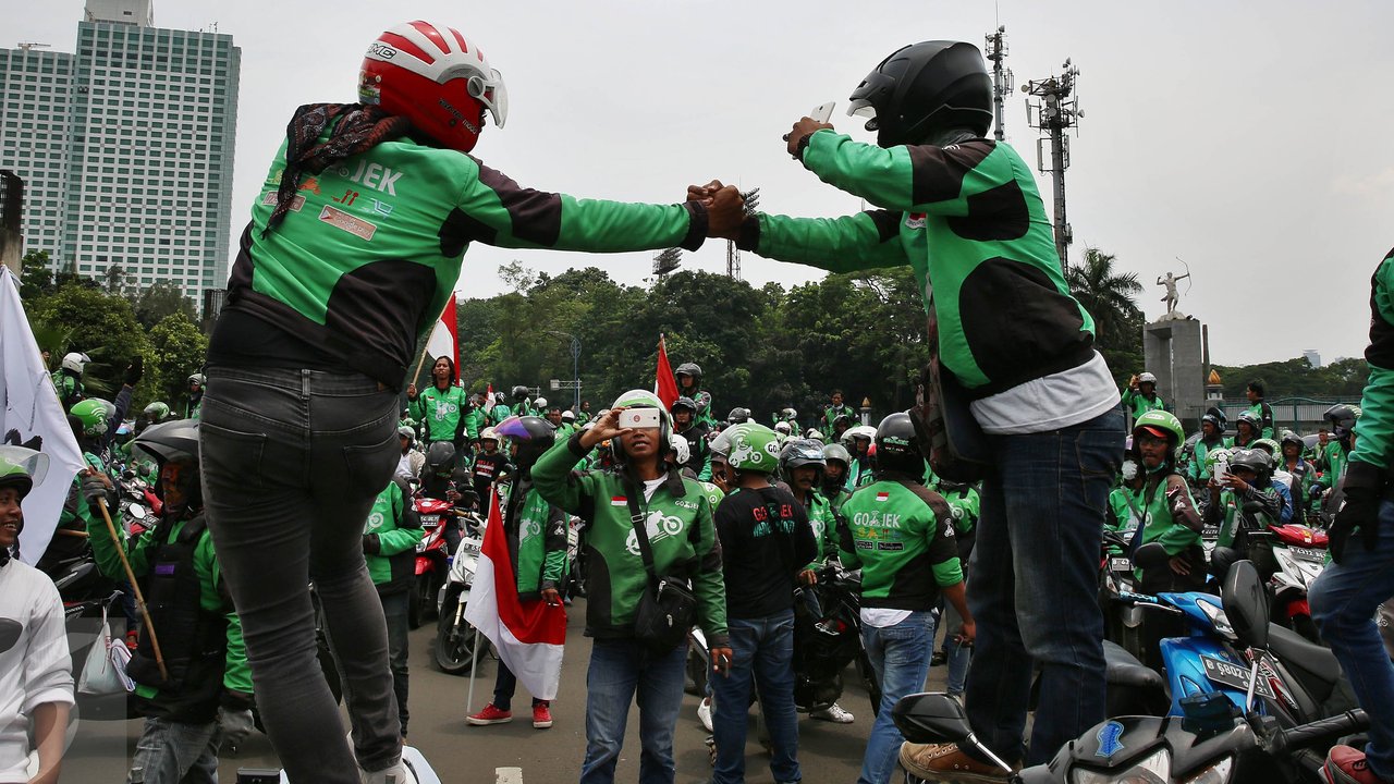 Driver Gojek berfoto saat berkumpul di jalan Asia Afrika, Jakarta, sebelum menggelar unjuk rasa ke kantor pusat mereka di Kemang, Senin (3/10). Ratusan pengemudi Gojek itu menuntut penghapusan sistem performa atau rating. (Liputan6.com/Johan Tallo)