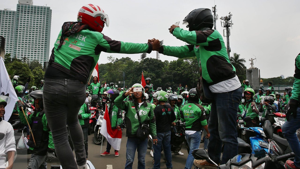 Driver Gojek berfoto saat berkumpul di jalan Asia Afrika, Jakarta, sebelum menggelar unjuk rasa ke kantor pusat mereka di Kemang, Senin (3/10). Ratusan pengemudi Gojek itu menuntut penghapusan sistem performa atau rating. (Liputan6.com/Johan Tallo)