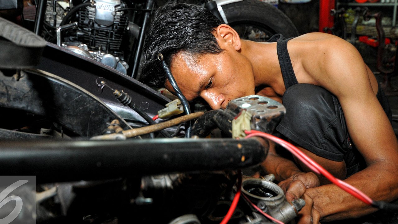Seorang teknisi tampak memperbaiki roda belakang sebuah sepeda motor, Jakarta, Selasa (14/7/2015). Menjelang H-3 Lebaran, bengkel servis motor di kawasan Pasar Minggu ramai didatangi pengendara yang ingin memperbaiki motornya.(Liputan6.com/Yoppy Renato)