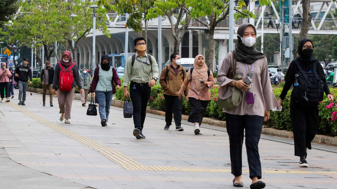 Pekerja saat melintas trotoar di kawasan Jend Sudirman, Jakarta, Selasa (21/11/2023)  Pemrov DKI Jakarta menetapkan Upah Minimum Provinsi (UMP) DKI Jakarta ditetapkan menjadi Rp 5.067.381, dari sebelumnya Rp 4.901.798. Jumlah tersebut naik sekitar Rp165.583.