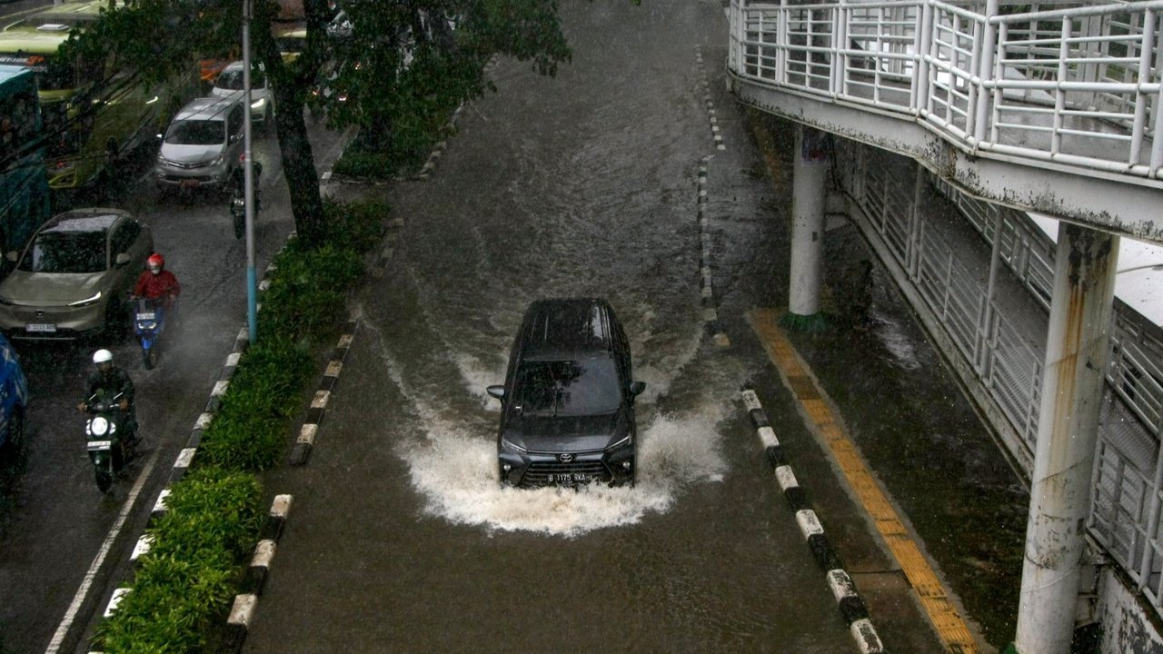Warga menerobos genangan banjir yang menutupi Jalan Suprapto, Cempaka Putih, Jakarta Pusat, Kamis (29/02/2024). Hujan yang mengguyur Jakarta sejak Kamis (29/02/2024) dini hari mengakibatkan sejumlah jalan di wilayah Cempaka Putih tergenang banjir hingga 70 cm.