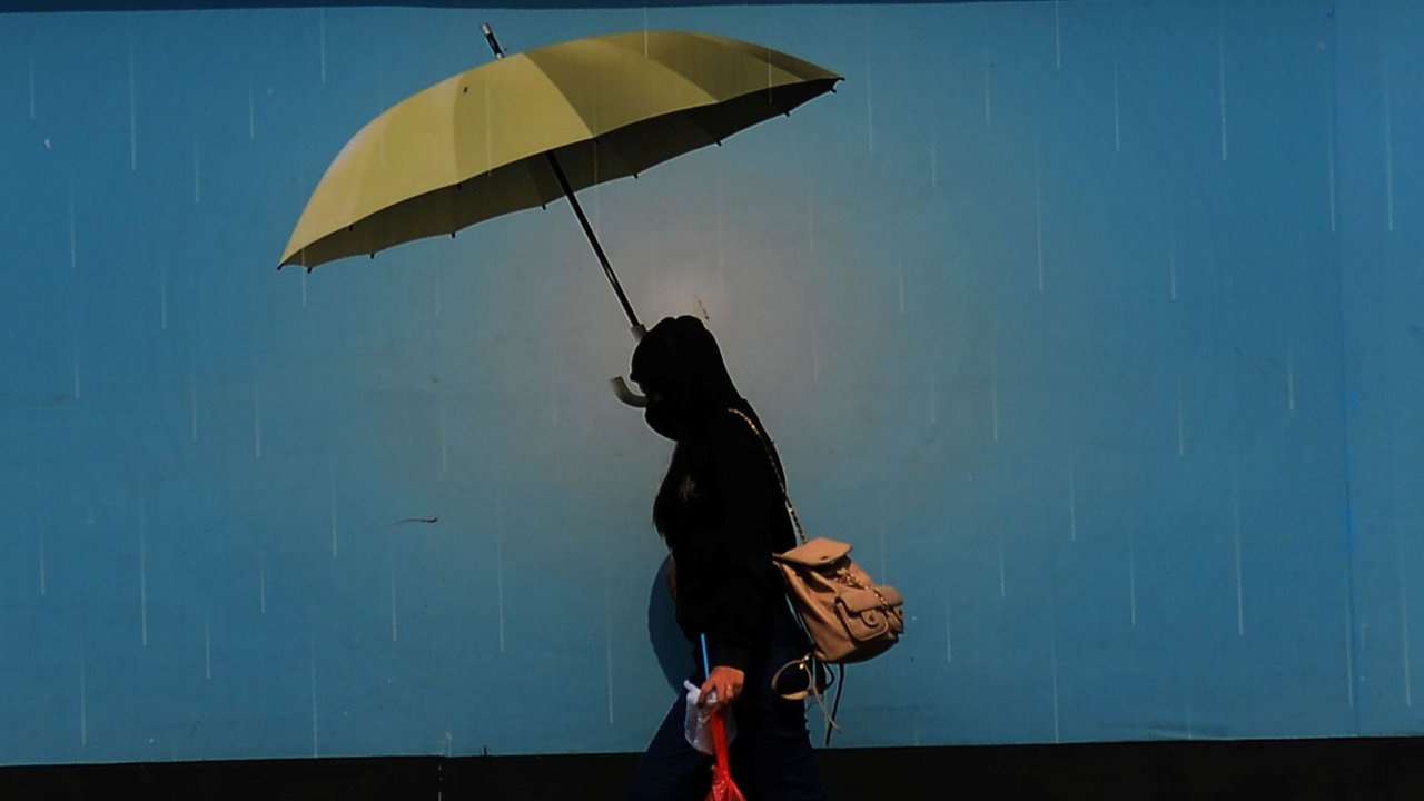 Pejalan kaki mengenakan payung untuk menghindari panas matahari di kawasan Kuningan, Jakarta, Selasa (26/9/2023). Hasil Monitoring ENSO Dasarian II September 2023 menunjukkan indeks ENSO (+1.65), sedangkan IOD sebesar (+1.26). Kondisi El Nino moderat dan IOD positif, diprediksi terus bertahan hingga akhir tahun 2023. merdeka.com/imam buhori