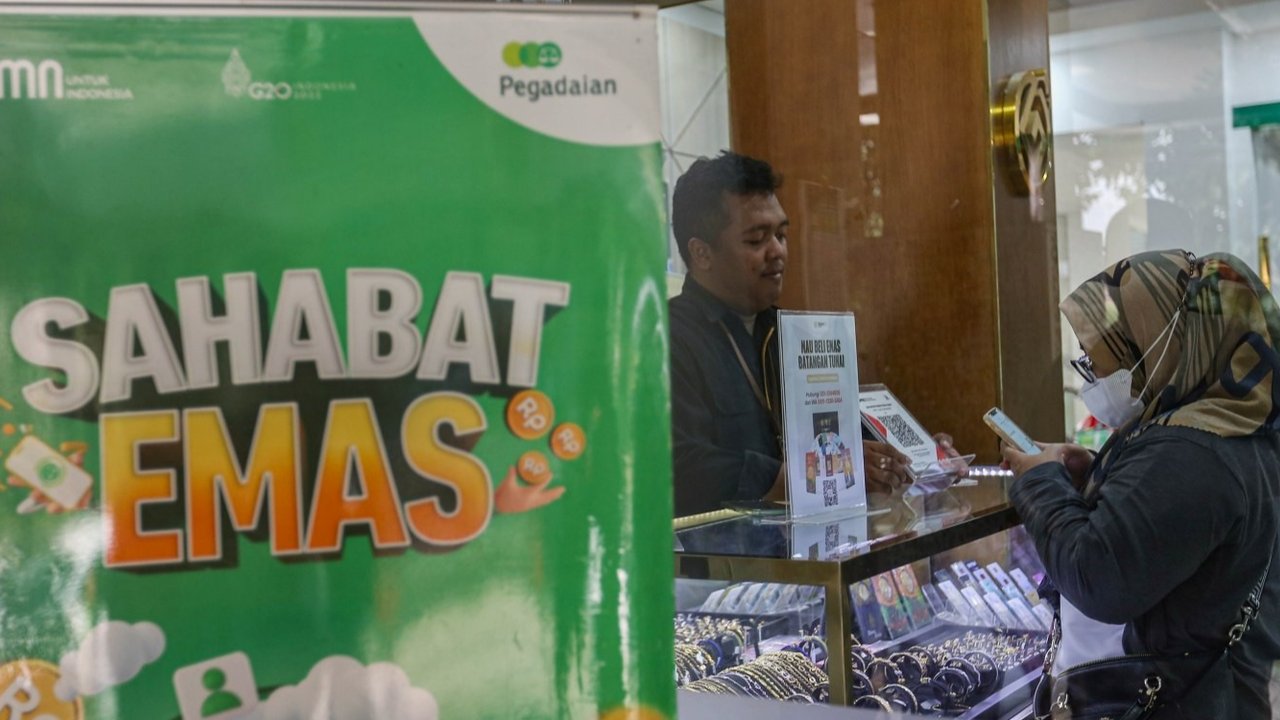 Petugas menunjukkan emas batangan di Galeri 24 Pegadaian, Jakarta, Senin (20/12/2024). Harga emas Antam batangan yang dipantau dari laman Logam Mulia, Senin (20/5) pagi mencapai rekor tertinggi yaitu sebesar Rp1.350.000 per gram, sedangkan untuk emas pegadaian dijual seharga 1.333.000 per gram. Liputan6.com/Angga Yuniar