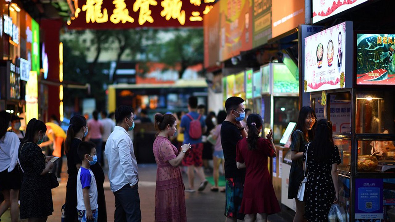 Warga mengantre untuk membeli makanan di pedagang kaki lima di Haikou, ibu kota Provinsi Hainan, China selatan (26/3/2020). Provinsi Kepulauan Hainan di China selatan pada Selasa (24/3) mencatatkan penurunan jumlah kasus penyakit coronavirus baru (COVID-19) yang ada menjadi nol. (Xinhua/Guo Cheng)