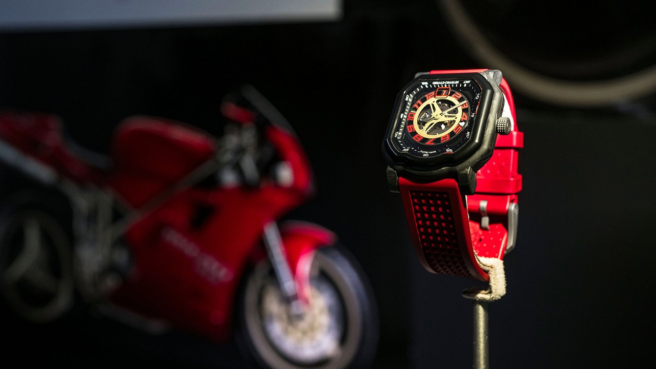 Jam ini menampilkan desain putaran waktu di atas roda sepeda motor.