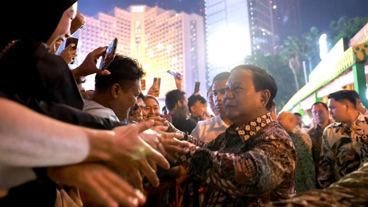 Presiden Prabowo Subianto menyapa warga saat menghadiri malam Tahun Baru 2025 di kawasan Bundaran HI, Jakarta, pada Rabu (1/1/2025).