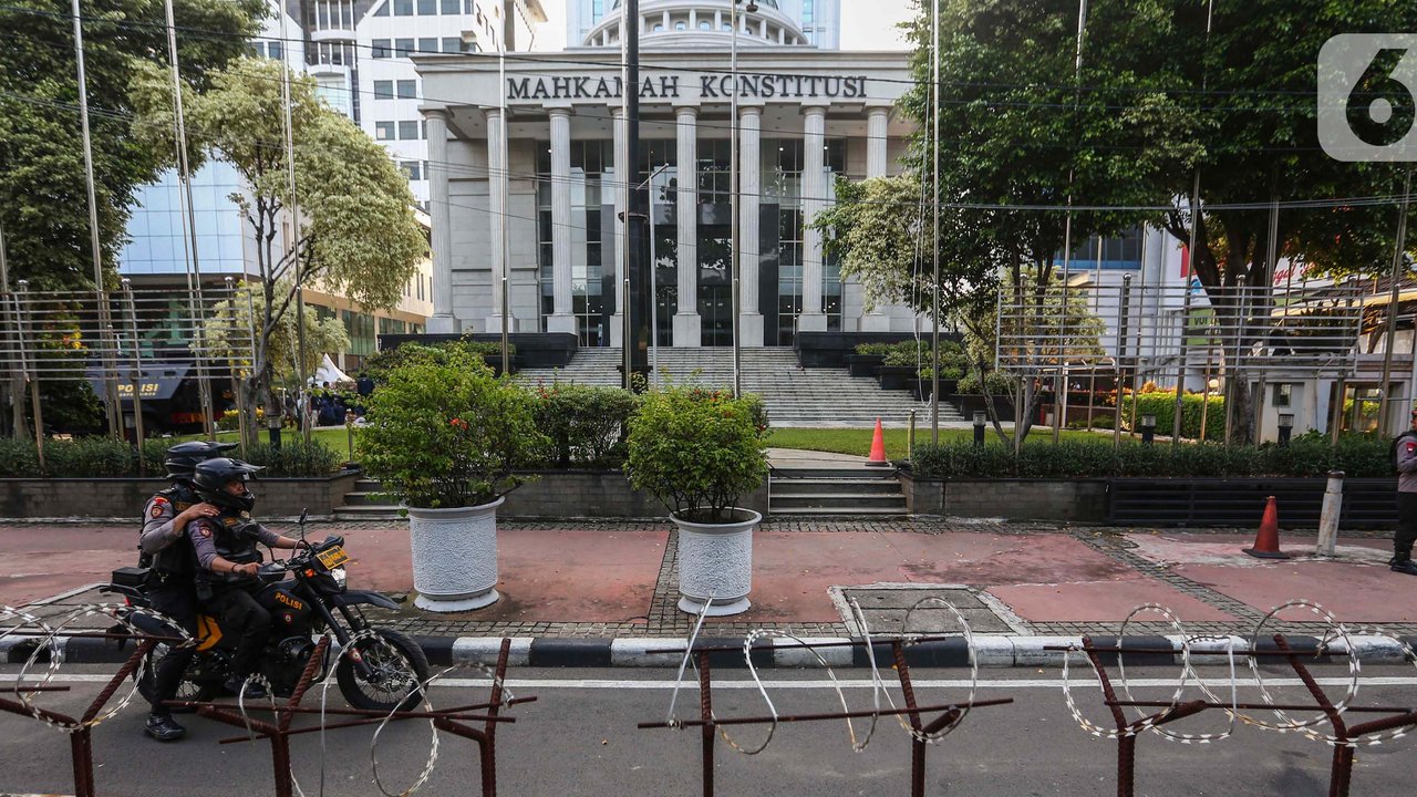 Petugas memasang beton pembatas dengan kawat berduri di halaman depan Gedung Mahkamah Konstitusi (MK) di Jakarta, Senin (25/3/2024). (Liputan6.com/Angga Yuniar)