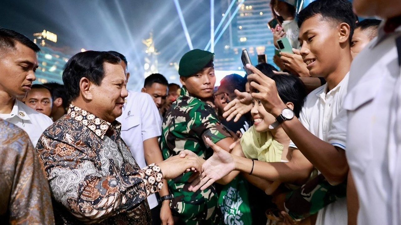 Presiden Prabowo Subianto menyawa warga yang meramaikan malam Tahun Baru 2025 di kawasan Bundaran HI, Jakarta, pada Rabu (1/1/2025).