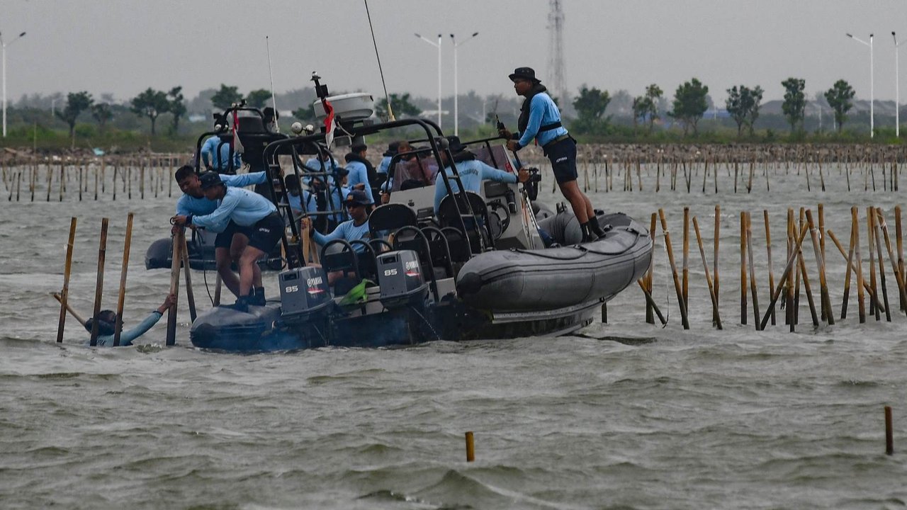 Pasukan TNI AL dan nelayan saat membongkar pagar laut di perairan Tanjung Pasir, Tangerang, Banten, pada Rabu (22/1/2024). Pembongkaran pagar laut ini melibatkan sebanyak 3.000 personel TNI AL, Kementerian Kelautan dan Perikanan (KKP), beserta nelayan.