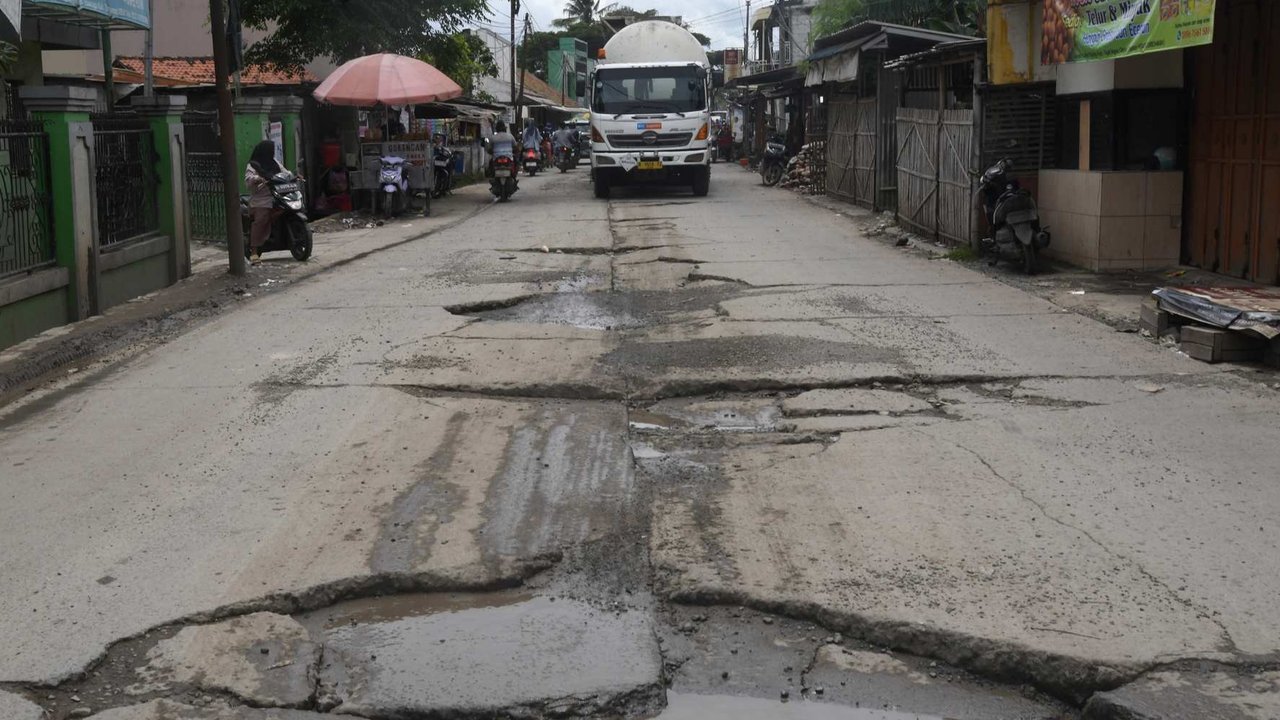 Sejumlah kendaraan melewati kondisi jalan yang rusak parah di Jalan Raya Tanjung Pasir, Tangerang, Banten, Rabu (22/01/2025).