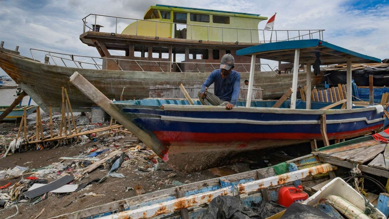 Warga menyelesaikan pembuatan perahu nelayan di Kampung Nelayan Tanjung Pasir, Tangerang, Banten, Rabu (22/1/2025).