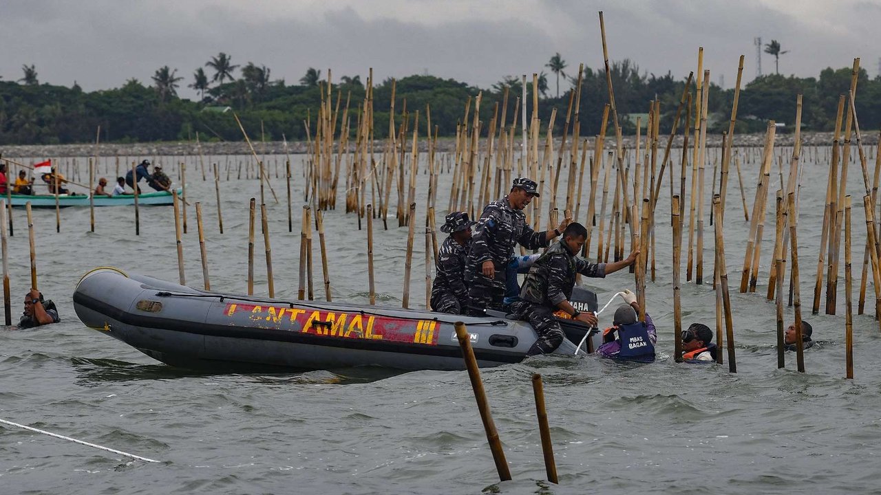 Pasukan TNI AL dan nelayan saat membongkar pagar laut di perairan Tanjung Pasir, Tangerang, Banten, pada Rabu (22/1/2024). Pembongkaran pagar laut ini melibatkan sebanyak 3.000 personel TNI AL, Kementerian Kelautan dan Perikanan (KKP), beserta nelayan.