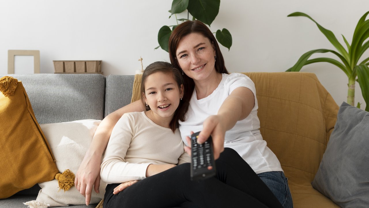 Seorang ibu yang ingin menonton televisi bersama anak perempuannya (Foto: Freepik/freepik).