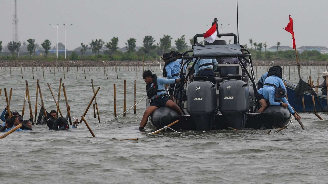 Pasukan TNI AL dan nelayan saat membongkar pagar laut di perairan Tanjung Pasir, Tangerang, Banten, pada Rabu (22/1/2024). Pembongkaran pagar laut ini melibatkan sebanyak 3.000 personel TNI AL, Kementerian Kelautan dan Perikanan (KKP), beserta nelayan.