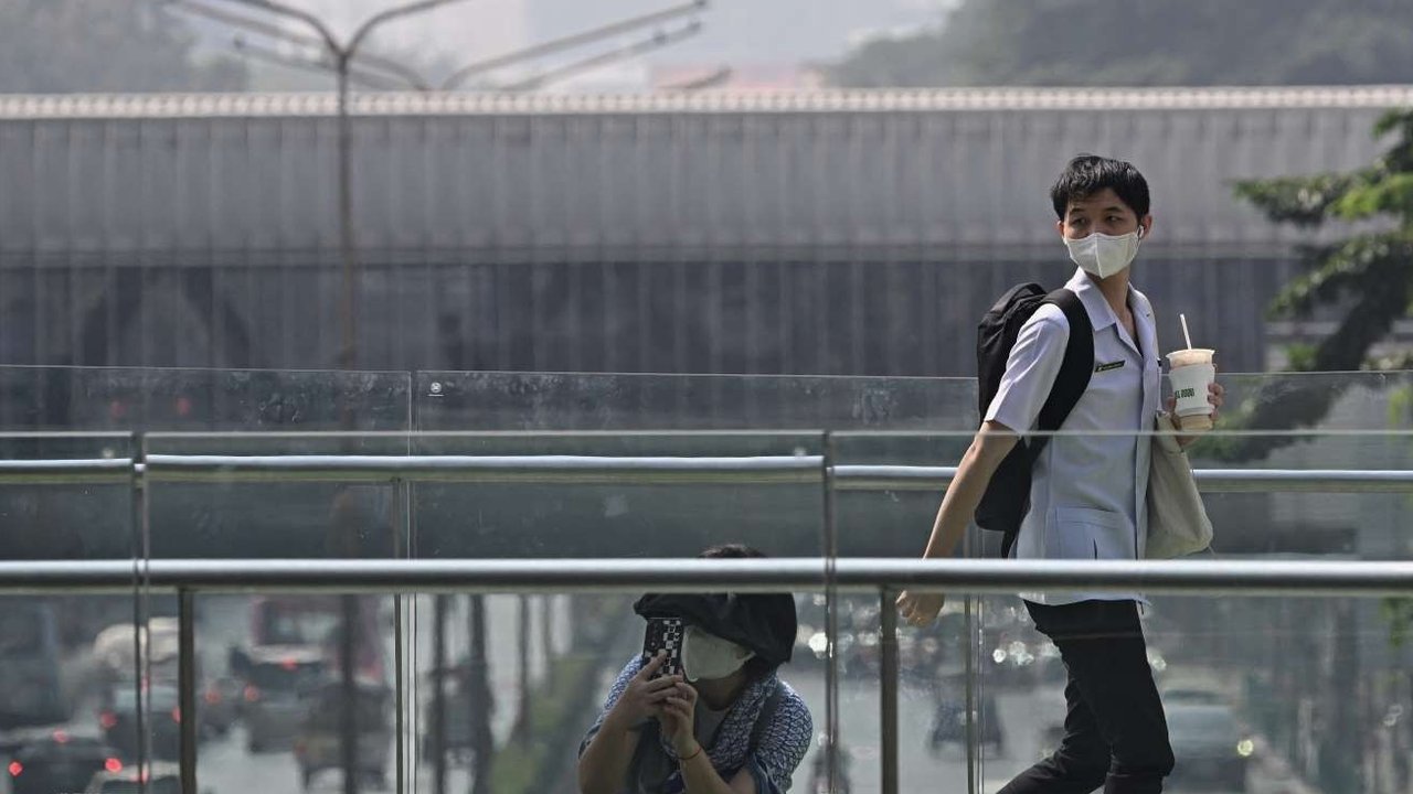Seorang warga mengenakan masker pelindung saat polusi udara tingkat tinggi menyelimuti Ibu Kota Bangkok, Thailand, pada Jumat (24/1/2025).