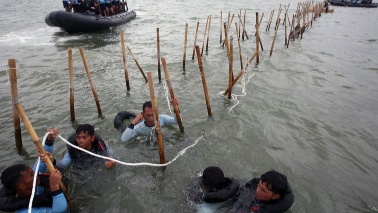 Pasukan TNI AL dan nelayan saat membongkar pagar laut di perairan Tanjung Pasir, Tangerang, Banten, pada Rabu (22/1/2024). Pembongkaran pagar laut ini melibatkan sebanyak 3.000 personel TNI AL, Kementerian Kelautan dan Perikanan (KKP), beserta nelayan.