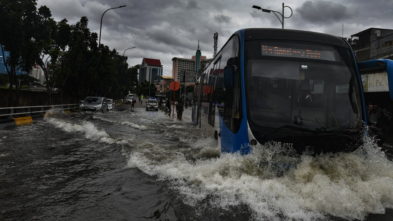 Bus TransJakarta melewati banjir yang merendam ruas Jalan Satria, Grogol, Jakarta Barat, Rabu (29/1/2025).