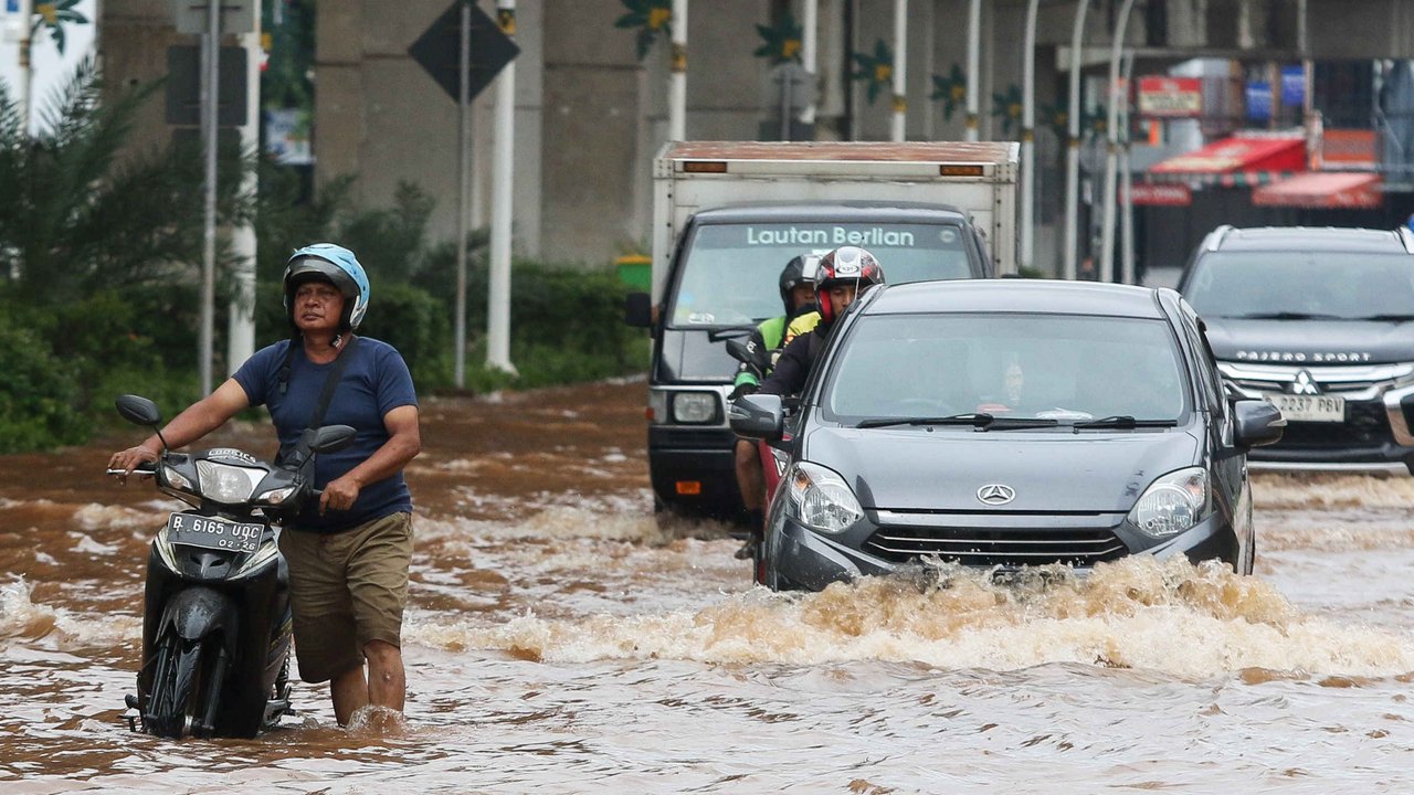 Pengendara melintasi banjir di Jalan Boulevard Raya, Kelapa Gading, Jakarta, Rabu (29/1/2025).