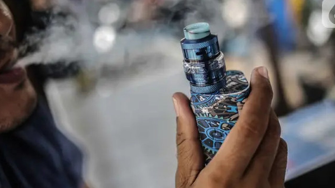 Seorang pria menggunakan vape atau rokok elektronik di kawasan Bundaran HI, Jakarta, Selasa (12/11/2019). Pemerintah melalui BPOM mengusulkan pelarangan penggunaan rokok elektrik dan vape di