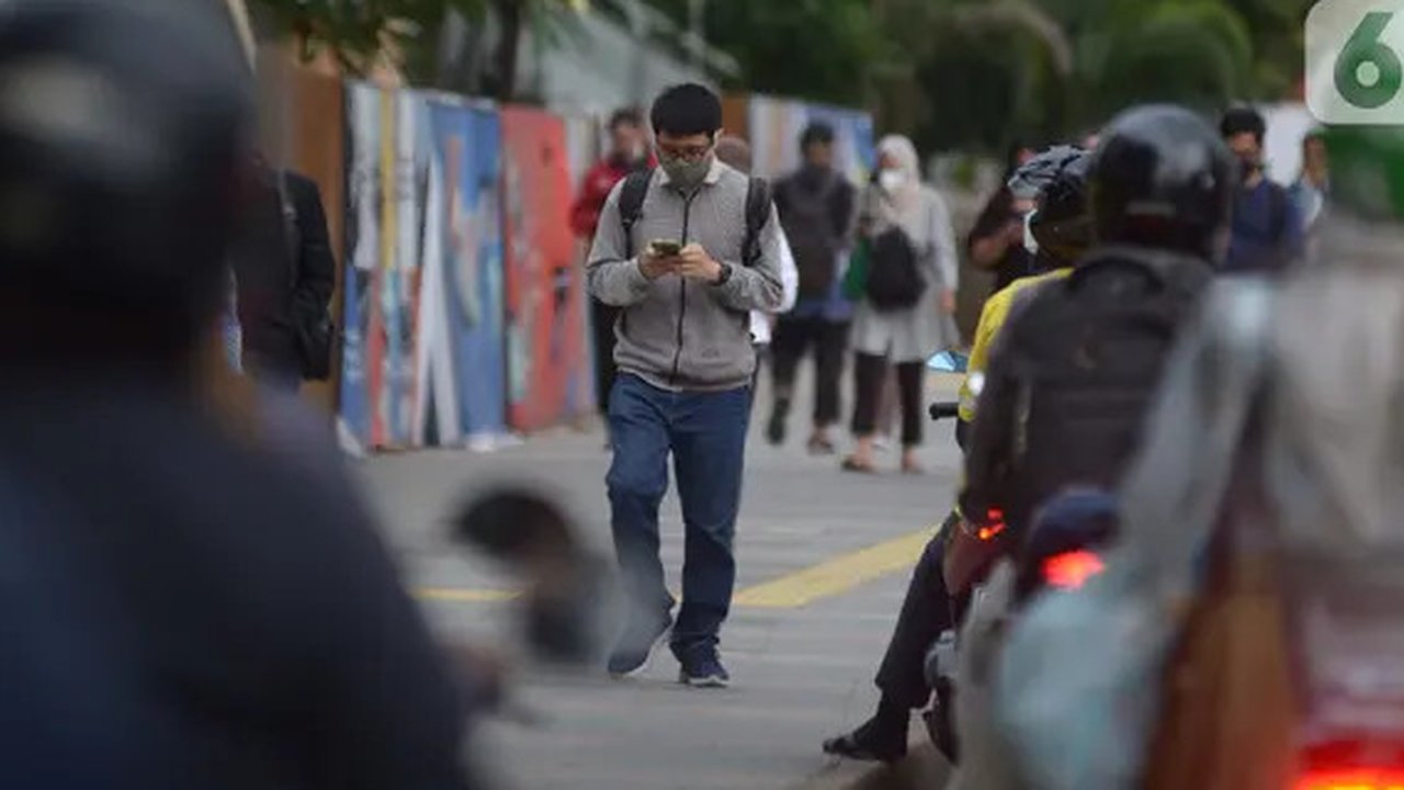 Karyawan perkantoran berjalan kaki  bergegas pulang di Kawasan Sudirman, Jakarta, Rabu (30/11/2022). Keputusan Pemerintah Provinsi (Pemprov) DKI Jakarta menaikan upah minimum provinsi (UMP) D