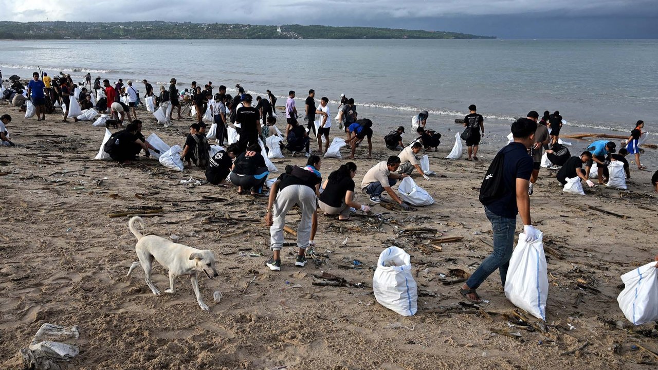 Relawan dan wisatawan membersihkan sampah plastik yang terdampar di pantai Kedonganan, Kabupaten Badung, Pulau Bali, Indonesia, (04/01/2024)
foto: AFP/Sonny Tumbelaka
