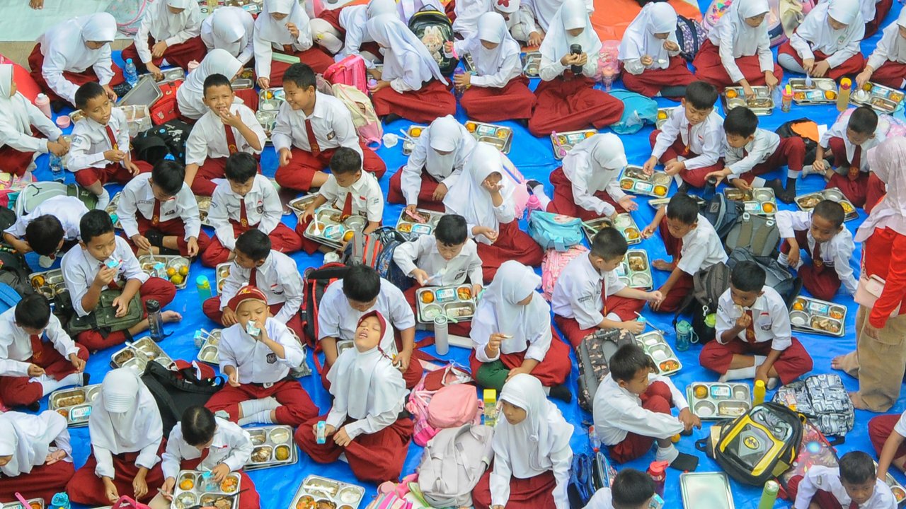 Sejumlah siswa menikmati Makan Bergizi Gratis (MBG) di SDN Lengkong Wetan 01, Tangerang Selatan, Banten, Senin (6/1/2024).