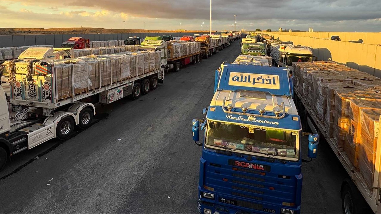Truk-truk bermuatan bantuan kemanusiaan terparkir menunggu akses ke Jalur Gaza di pertabatasan Mesir, Minggu (12/10/2025).